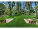 Scenic horseshoe pit surrounded by lush landscaping and mature trees with bench seating nearby at 11719 Foxworth Ln, New Port Richey, FL 34654