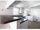 Kitchen featuring white cabinets, dark countertops, stainless steel sink, and updated appliances at 12140 74Th St, Largo, FL 33773