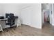 Well-lit office space showing white walls, wood floor, and a view of the hallway at 12140 74Th St, Largo, FL 33773