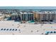 Aerial view showing beachfront condos with pools, beach, and palm trees at 12924 Gulf Blvd # 502, Madeira Beach, FL 33708