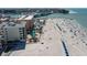 An aerial view showcasing a condominium building near a sandy beach and a refreshing community pool at 12924 Gulf Blvd # 502, Madeira Beach, FL 33708