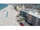Aerial view showing the beachfront condominiums, pool, and sandy beach near the ocean at 12924 Gulf Blvd # 502, Madeira Beach, FL 33708