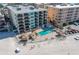 Aerial view of beachfront condo with a pool, huts, and beach access at 12924 Gulf Blvd # 502, Madeira Beach, FL 33708