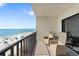 Private condo balcony with two chairs and a small table overlooking ocean views and private beach at 12924 Gulf Blvd # 502, Madeira Beach, FL 33708
