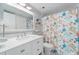 Bathroom with bright vanity, stylish mirror, and colorful shower curtain at 12924 Gulf Blvd # 502, Madeira Beach, FL 33708
