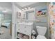 Clean and tidy bathroom with open shelving and coastal artwork at 12924 Gulf Blvd # 502, Madeira Beach, FL 33708