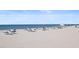 Picturesque beach scene with clear blue waters, soft sand, and rows of relaxing beach chairs at 12924 Gulf Blvd # 502, Madeira Beach, FL 33708