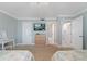 Comfortable bedroom showcasing dresser with TV and open bathroom entrance at 12924 Gulf Blvd # 502, Madeira Beach, FL 33708