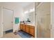 A well-lit bathroom with a vanity sink, enclosed shower and tan colored tile at 12934 Tikal Way, Trinity, FL 34655