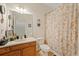 Cozy bathroom featuring seashell-themed decor, a vanity sink, and a toilet with patterned shower curtain at 12934 Tikal Way, Trinity, FL 34655