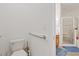 A bright bathroom with a toilet and shower, featuring tile flooring and a grab bar at 12934 Tikal Way, Trinity, FL 34655