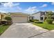 The property has a two-car garage and lush landscaping adding curb appeal to the facade at 12934 Tikal Way, Trinity, FL 34655