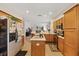 Spacious kitchen featuring wooden cabinets, an island, and views of the living room at 12934 Tikal Way, Trinity, FL 34655