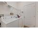 Bright laundry room with washer, dryer, wire shelving, and a door, providing convenience and storage at 12934 Tikal Way, Trinity, FL 34655