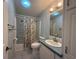 Cozy bathroom with a shower-tub combo, vanity, and charming wallpaper at 131 E Saint Annes Cir, Apollo Beach, FL 33572