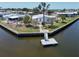 Waterfront home featuring dock, lush landscaping, and mature palm trees at 131 E Saint Annes Cir, Apollo Beach, FL 33572