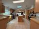Open kitchen with wood cabinetry, tiled floor, stainless steel appliances and a center island at 131 E Saint Annes Cir, Apollo Beach, FL 33572
