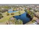 Scenic aerial view of the golf course, displaying a beautiful pond, trees, and greenery at 16323 Muirfield Dr, Odessa, FL 33556