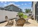 Outdoor patio area with brick pavers and a fire pit with white fencing and side yard at 16323 Muirfield Dr, Odessa, FL 33556