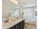 Bright bathroom with double vanity, framed mirrors, and shower-tub combination at 16323 Muirfield Dr, Odessa, FL 33556
