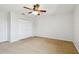 Spacious carpeted bedroom featuring a ceiling fan and a double door closet for ample storage at 16323 Muirfield Dr, Odessa, FL 33556