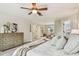 Comfortable bedroom featuring a queen bed, a ceiling fan, and a dresser at 16323 Muirfield Dr, Odessa, FL 33556