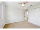 Bedroom showcasing a ceiling fan, carpet, closet and view to the backyard through a window at 16323 Muirfield Dr, Odessa, FL 33556