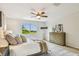 Comfortable bedroom featuring a queen bed, a ceiling fan, and a window with a scenic view at 16323 Muirfield Dr, Odessa, FL 33556