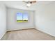 Bedroom featuring neutral walls, carpet, a ceiling fan, and a large window at 16323 Muirfield Dr, Odessa, FL 33556