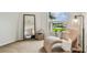 A bright bedroom sitting area with a curved chaise lounge and a large mirror reflecting the room at 16323 Muirfield Dr, Odessa, FL 33556