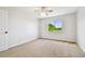 Bedroom featuring neutral walls, carpet, and a window with a backyard view at 16323 Muirfield Dr, Odessa, FL 33556