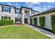 Stunning two-story home featuring manicured landscaping and a modern architectural design with clean lines and dark trim at 16323 Muirfield Dr, Odessa, FL 33556