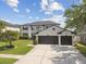 Elegant two-story home featuring a spacious driveway and a three-car garage, set on a well-manicured lawn at 16323 Muirfield Dr, Odessa, FL 33556