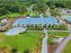 Aerial view of a golf course clubhouse with patio seating, a meticulously manicured lawn and landscaping at 16323 Muirfield Dr, Odessa, FL 33556