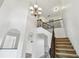 Bright foyer with a chandelier, an elegant staircase, and an open layout with views into other rooms at 16323 Muirfield Dr, Odessa, FL 33556