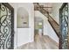 Bright foyer with wood floors, a staircase with dark wood railings, and a view of the pool through the doorway at 16323 Muirfield Dr, Odessa, FL 33556