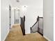 Hallway with carpet, stairs, and three doors leading to rooms, offering functional space at 16323 Muirfield Dr, Odessa, FL 33556