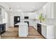 Contemporary kitchen with white cabinetry, stainless steel appliances, an island, and wood-look flooring at 16323 Muirfield Dr, Odessa, FL 33556