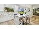 Bright and open kitchen with an island featuring counter seating, white cabinets, and stainless steel appliances at 16323 Muirfield Dr, Odessa, FL 33556