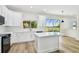 Bright kitchen featuring white cabinets, quartz countertops, an island, and sliding glass doors leading to the patio at 16323 Muirfield Dr, Odessa, FL 33556