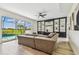 Spacious living room featuring a large sectional sofa and a black built-in bookcase and pool views at 16323 Muirfield Dr, Odessa, FL 33556
