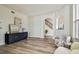 Bright living room featuring hardwood floors, modern furniture, a blue cabinet, and an arched doorway leading to the staircase at 16323 Muirfield Dr, Odessa, FL 33556