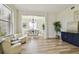 Open-concept living area with hardwood floors, plush seating, a cabinet, and a view into the adjacent dining room at 16323 Muirfield Dr, Odessa, FL 33556