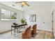Bright home office with light wood floors, modern desk, and cozy sitting area under a ceiling fan at 16323 Muirfield Dr, Odessa, FL 33556