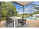 Screened outdoor dining area next to pool with a dining table and chairs with a view of a field at 16323 Muirfield Dr, Odessa, FL 33556