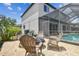 Outdoor patio area with brick pavers and a fire pit with views of the screened pool and outdoor living at 16323 Muirfield Dr, Odessa, FL 33556