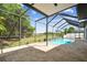 A screened-in pool with brick pavers and tranquil views of the fenced-in backyard at 16323 Muirfield Dr, Odessa, FL 33556