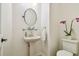 Cozy powder room featuring pedestal sink, decorative mirror and purple orchid accents at 16323 Muirfield Dr, Odessa, FL 33556