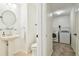 View of a powder room with a pedestal sink, toilet and doorway to the laundry room at 16323 Muirfield Dr, Odessa, FL 33556