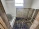 Bathroom features tub, window, blue tiled floor, and unfinished wall work at 1715 Delaware Ne Ave, St Petersburg, FL 33703